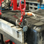 Sähköauton akku kiinnitetty nostotelineeseen ketjuilla